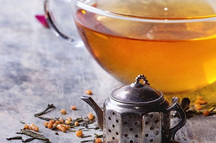 Cup of tea with tea leaves and infuser